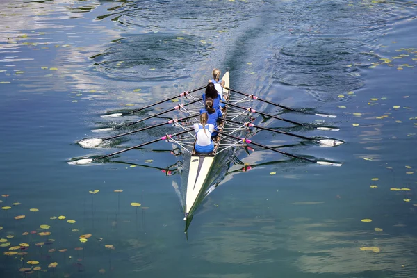 Quatro mulheres remando no lago tranquilo — Fotografia de Stock