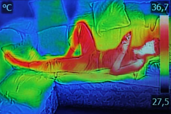 Инфракрасное изображение, показывающее тепловое излучение, когда женщина использует смартф — стоковое фото