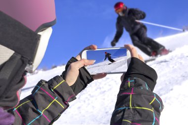 Photographed skiers with mobile phone clipart