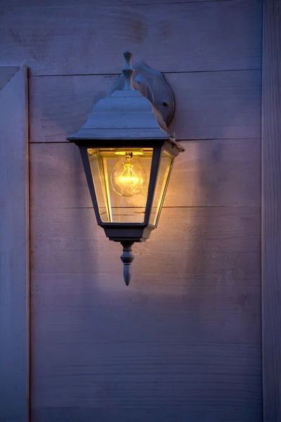 Antiguo farol ardiendo en las paredes de madera —  Fotos de Stock