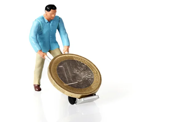 Trabajador en miniatura conduce monedas de euro — Foto de Stock