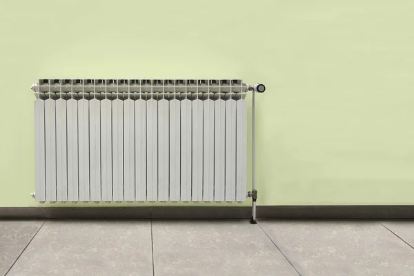 Šedé radiátor na žluté zdi — Stock fotografie
