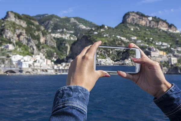 Chica tomar fotos utilizar el teléfono celular, de Atrani en el famoso Amalfi Coa —  Fotos de Stock