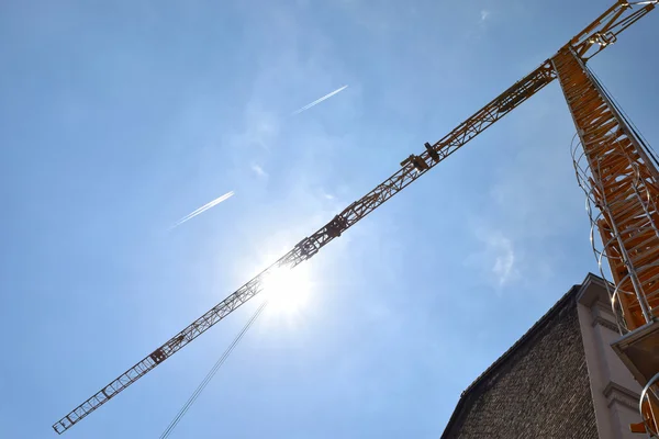 Grue de construction, ciel bleu et soleil — Photo