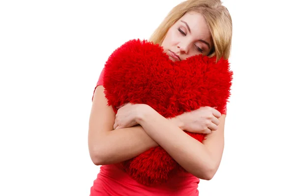 Mädchen umarmt rotes Herzkissen — Stockfoto