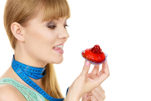 Mulher segura cupcake tentando resistir à tentação — Fotografia de Stock