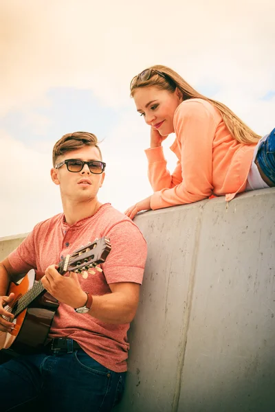 Gelukkige paar met gitaar buiten — Stockfoto