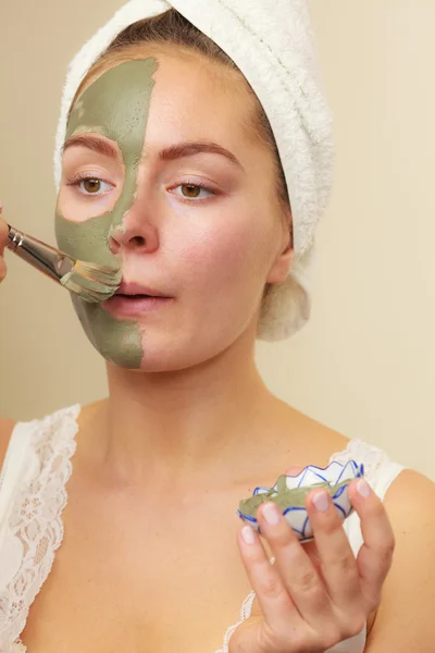 Woman applying with brush clay mud mask to her face — Stock Photo, Image