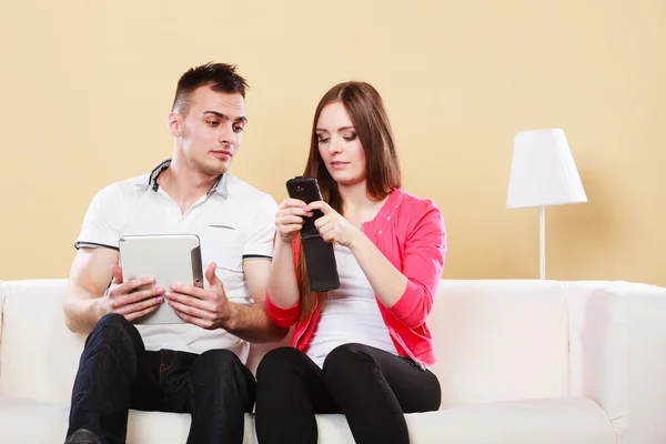 Couple using tablet mobile phone texting messages — Stok fotoğraf