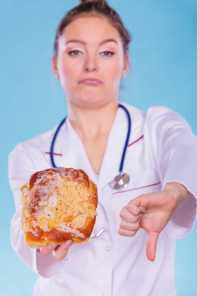 Diëtist met zoete roll broodje. Ongezonde junkfood — Stockfoto