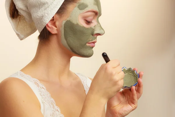 Femme appliquant avec un masque de boue d'argile brosse sur son visage — Photo