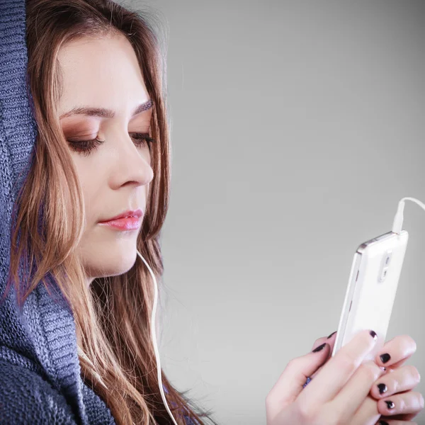 Mujer joven con teléfono inteligente escuchar música — Foto de Stock