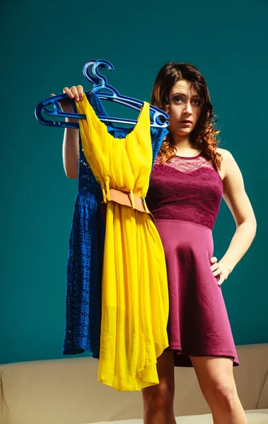 Woman customer holding hangers with clothes — Stock Photo, Image