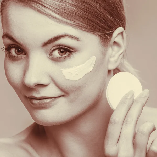 Woman removing makeup with cream and cotton pad — Stock Photo, Image