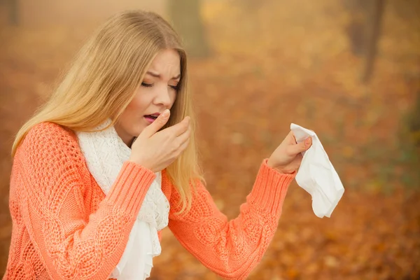 Woman sneezing in tissue — Stock Photo, Image