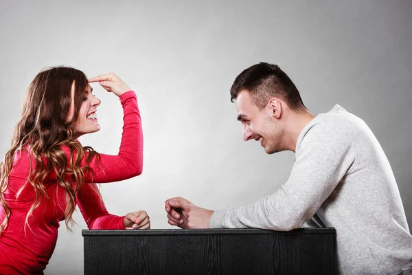 Mädchen gestikuliert mit Finger vor Mann sitzend — Stockfoto