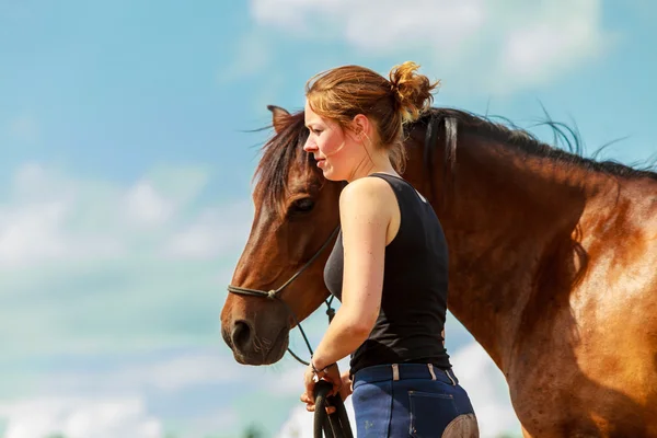 Jonge vrouw meisje het verzorgen van het paard. — Stockfoto