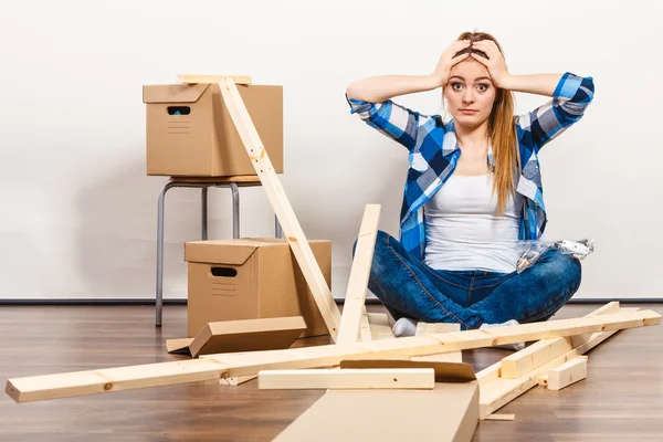 Woman moving into apartment assembly furniture. — Stock Image Woman moving into apartment assembly furniture. Stock Photo