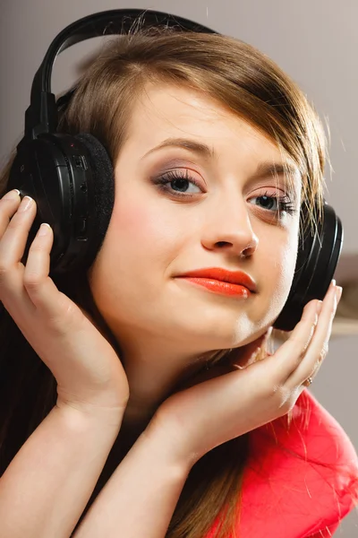 Technologie, muziek - lachend jong meisje in koptelefoon — Stockfoto