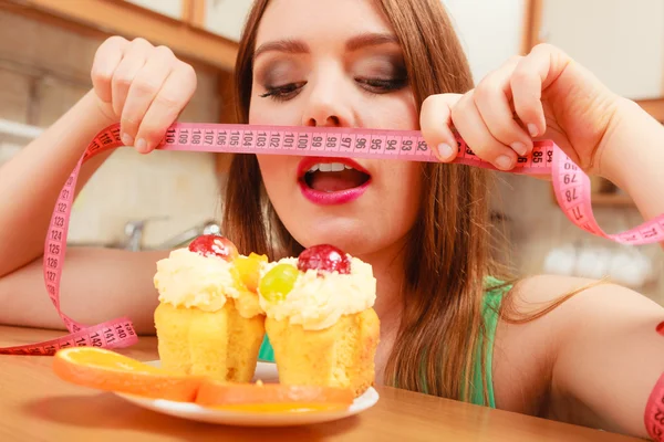 Mulher com fita métrica e bolo. Dilema da dieta . — Fotografia de Stock