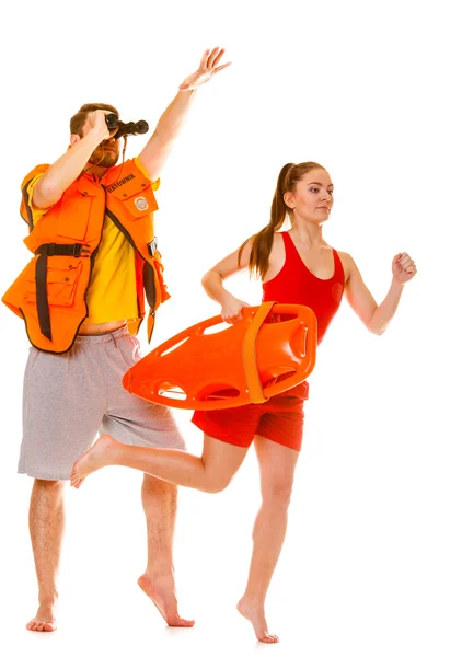 Lifeguards in life vest with rescue buoy running — Stock Photo, Image