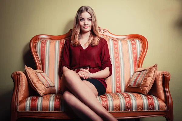 Woman sitting on vintage retro sofa — Stock Photo, Image