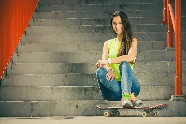 Mädchen mit Skateboard sitzend — Stockfoto