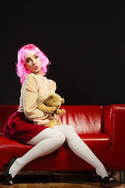 Childlike woman and teddy bear sitting on couch — Stock Photo, Image