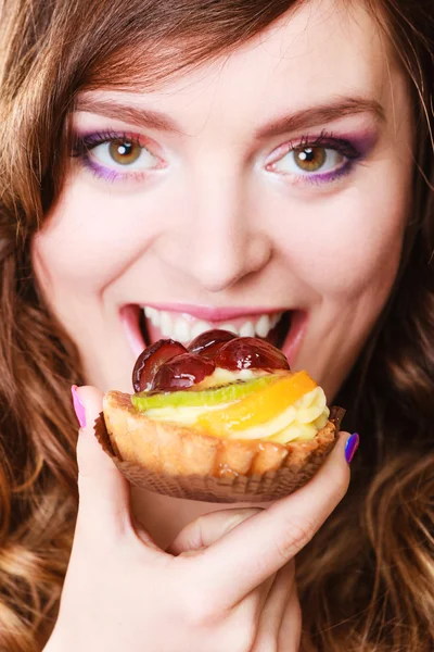 Mulher com bolo de frutas na boca — Fotografia de Stock