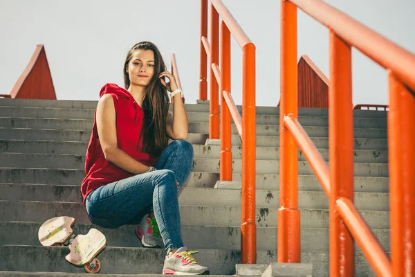 Chica de skate en las escaleras con monopatín . — Foto de Stock