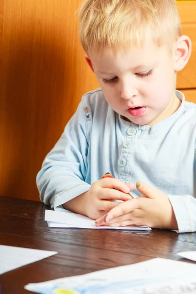 ペンの書き込みの男の子の子供の宿題をやっています。家に. — ストック写真