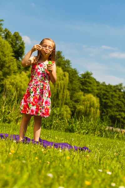 Liten flicka barn blåsa bubblor utomhus. — Stockfoto