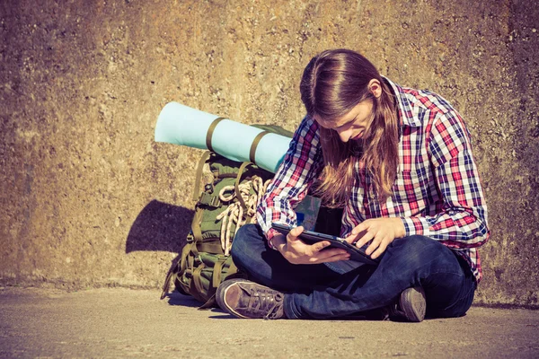 Backpacker τουριστικά άνθρωπος κάθεται με tablet εξωτερική — Φωτογραφία Αρχείου