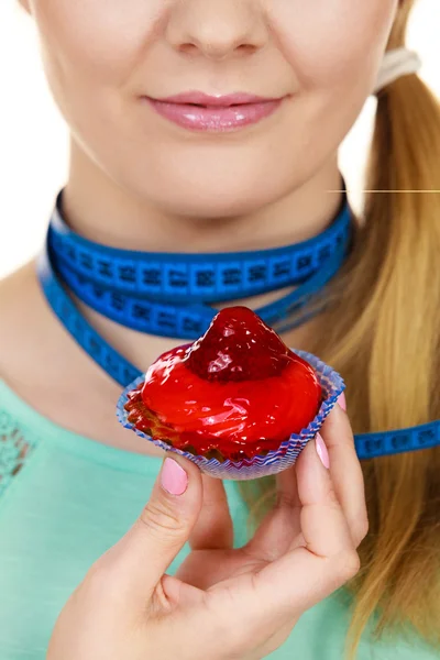 Woman holds cupcake trying to resist temptation — Stock Photo, Image