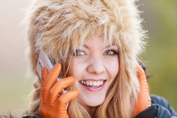 Donna sorridente in cappello di pelliccia che parla sul cellulare . — Foto Stock