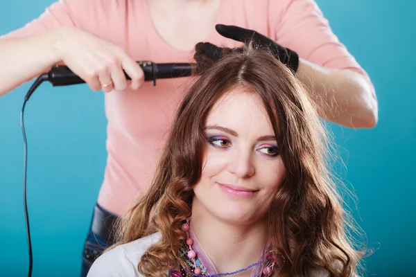 Cabeleireiro curling cabelo mulher com frisador de ferro. — Fotografia de Stock