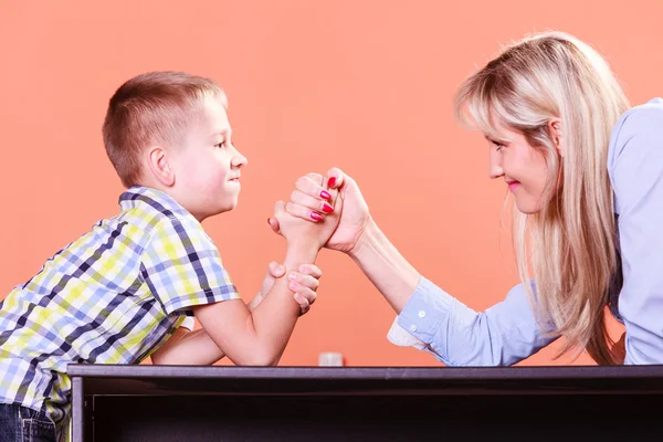 Mother and son arm wrestle sit at table. — Stock Photo, Image