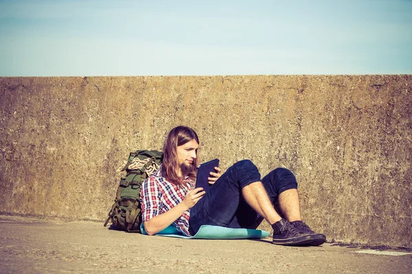 Homme sac à dos touristique assis avec tablette extérieure — Photo