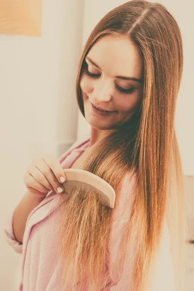 Kvinnan kamma hennes långa hår i badrum — Stockfoto