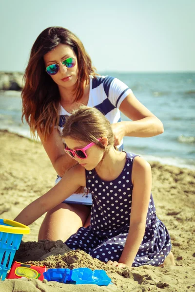 Famiglia madre e figlia si divertono sulla spiaggia . — Foto Stock