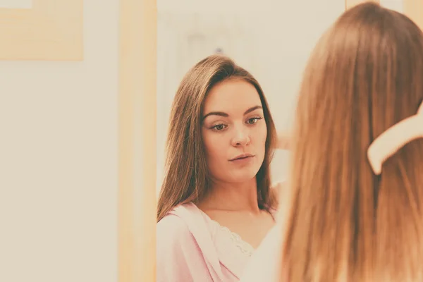 Mujer peinándose el pelo largo — Foto de Stock