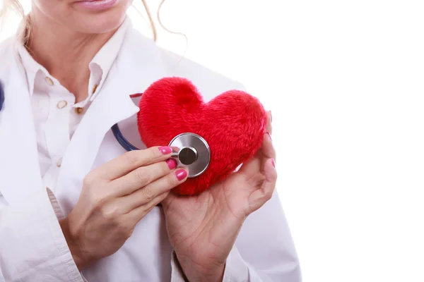 Arzt mit Stethoskop untersucht rotes Herz. — Stockfoto