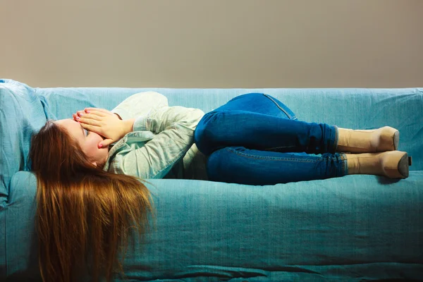 Sad woman laying on couch — Stock Photo, Image