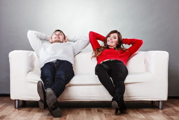 Pareja feliz descansando en el sofá en casa. —  Fotos de Stock