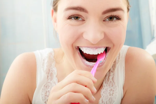 Jeune femme brossant les dents — Photo