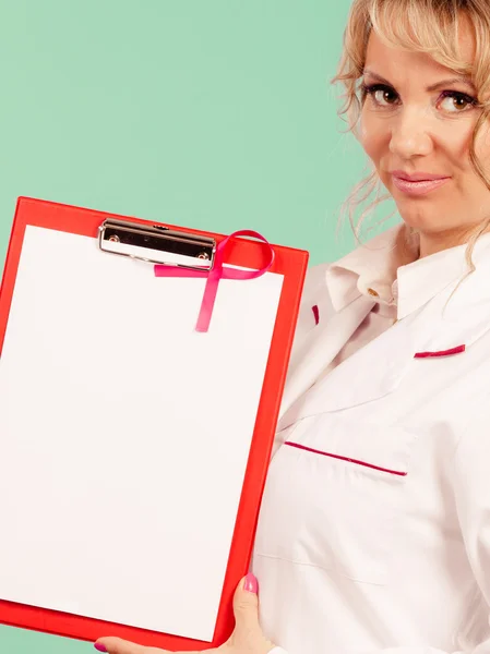 Женщина-врач с папкой и розовой лентой — стоковое фото