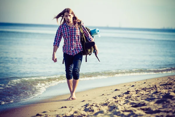 Hombre excursionista con mochila vagando por la playa — Foto de Stock