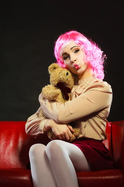 Childlike woman and teddy bear sitting on couch — Stock Photo, Image