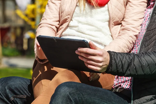 Couple with  tablet sitting on bench — Stock Photo, Image