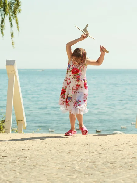 小女孩孩子在海滩与纸飞机飞机 — 图库照片